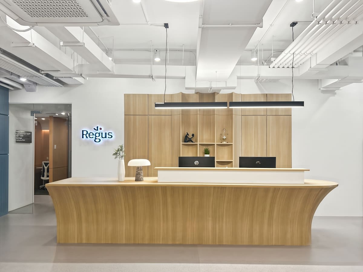 Stylish reception with modern design and ample lighting, ideal for a dynamic coworking environment.