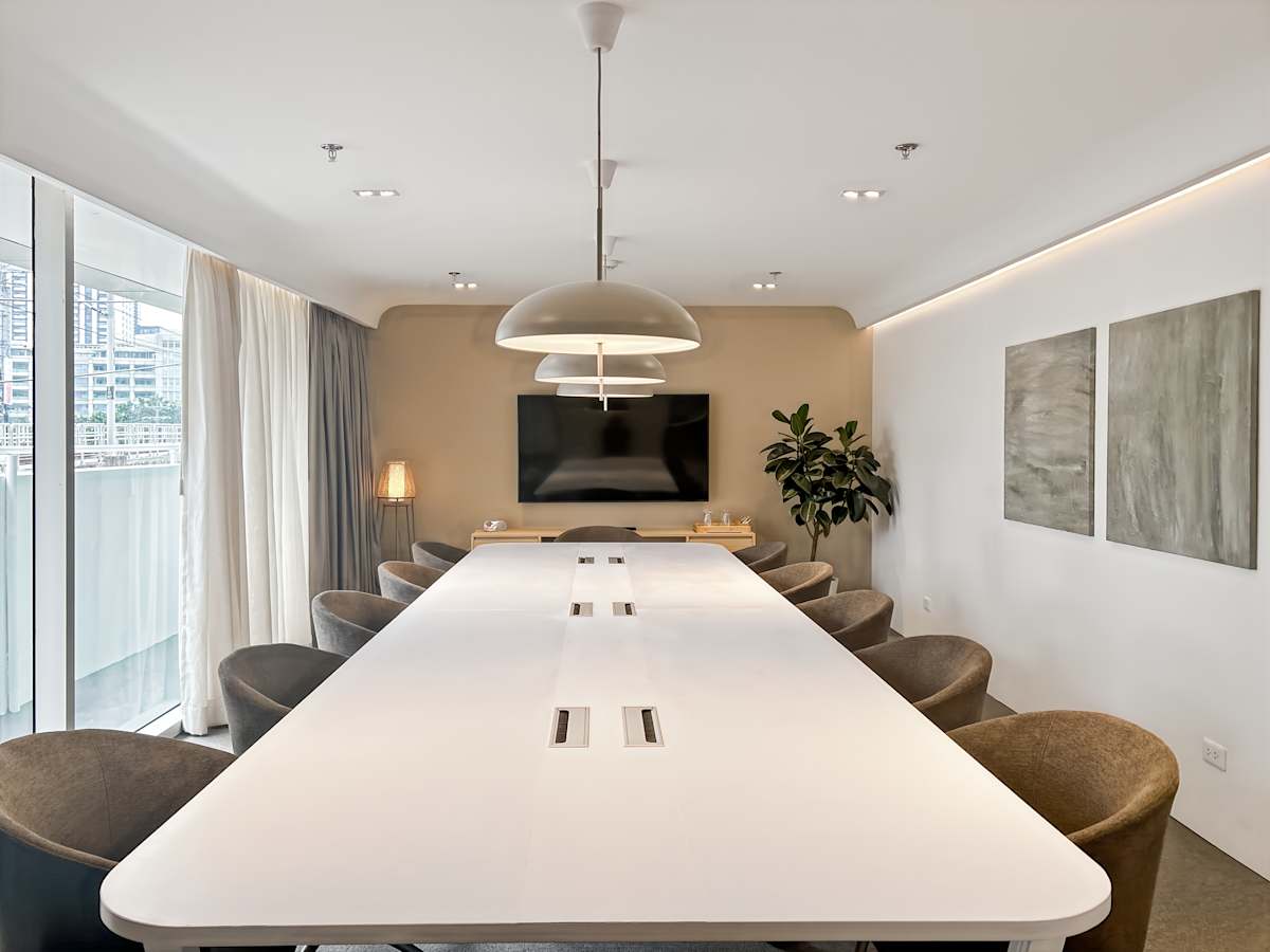 Elegant meeting room with modern lighting, spacious seating, and natural light. Ideal for collaboration.