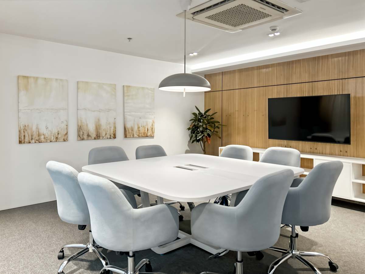 Modern meeting room with sleek design, plush seating, and multimedia setup. Ideal for collaboration.