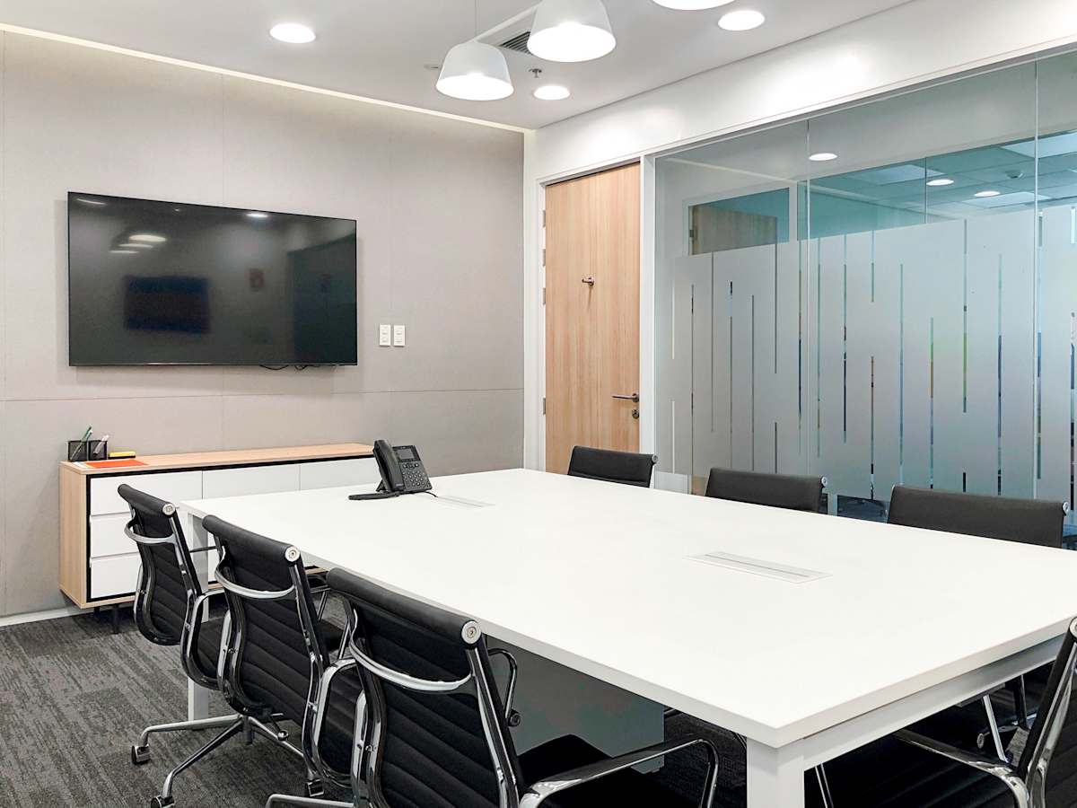 Modern conference room with sleek furnishings, whiteboard, and ample natural light. Perfect for collaboration.