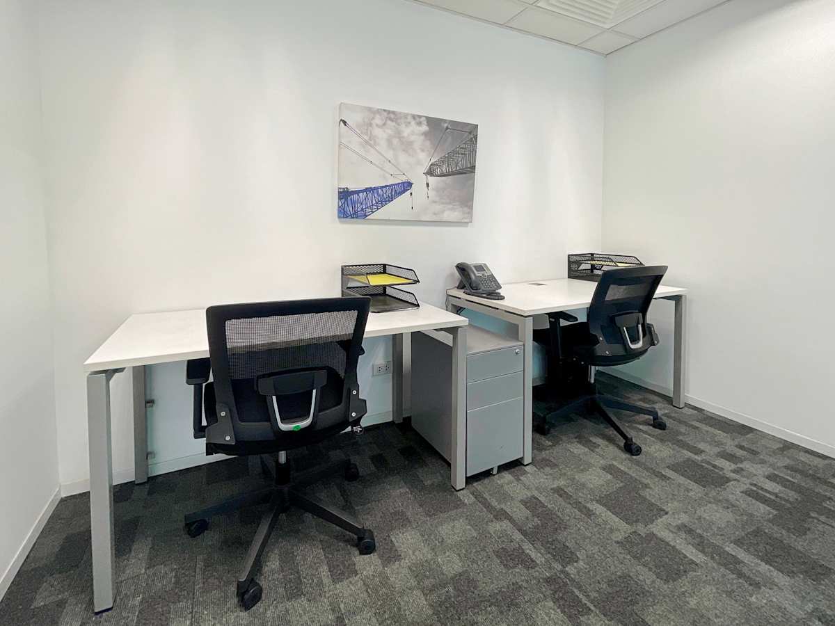 Modern coworking space with sleek desks, ergonomic chairs, and ample lighting. Ideal for productivity.