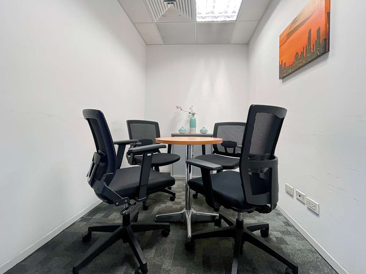 Modern meeting nook with ergonomic chairs and vibrant artwork in a Metro Manila coworking space.