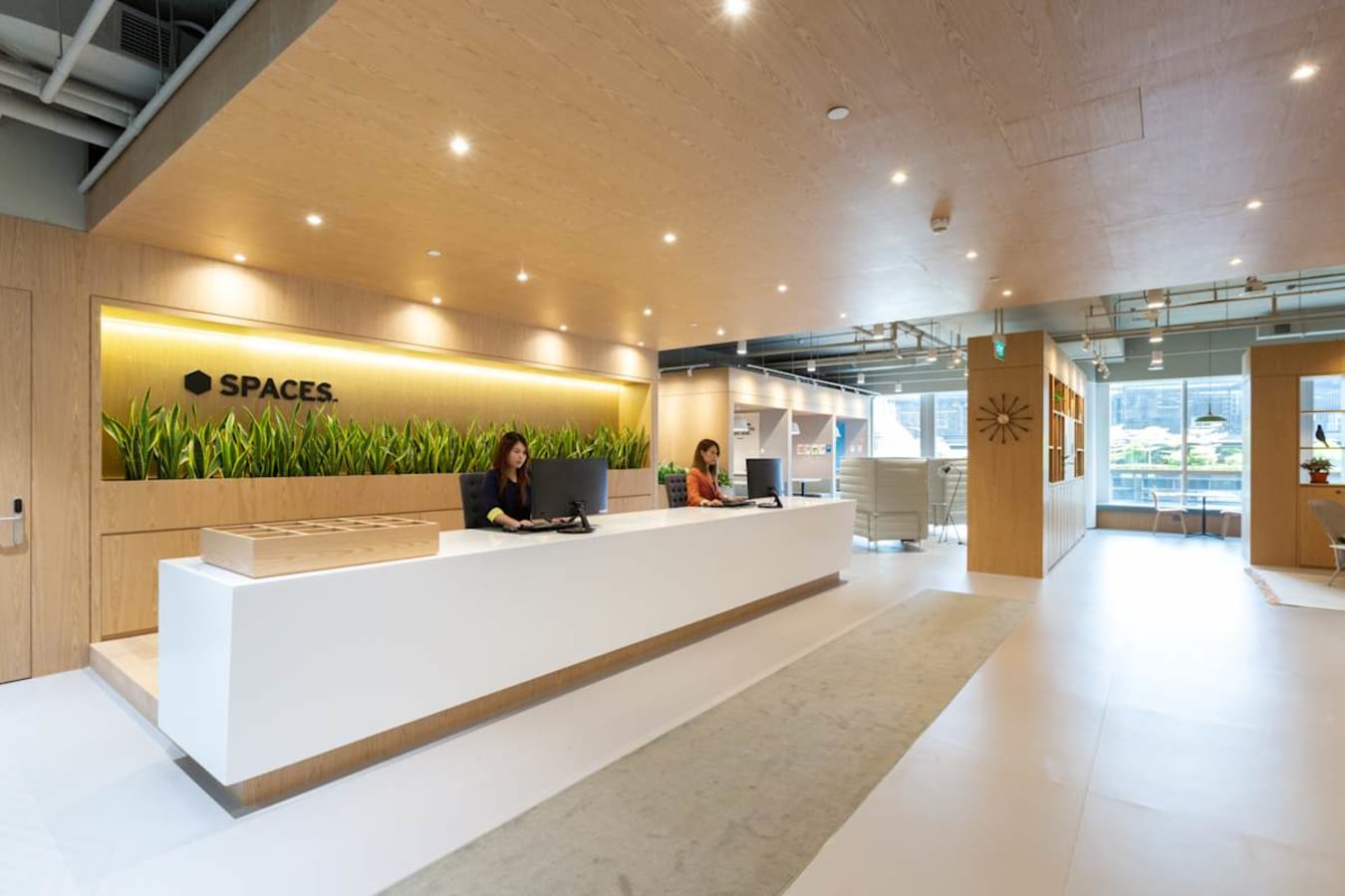 Modern coworking area with sleek design, abundant natural light, and welcoming reception.