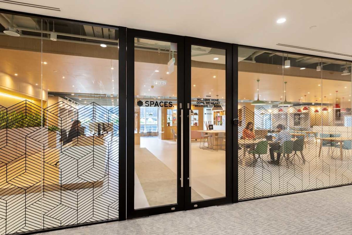 Modern coworking space with glass doors, stylish decor, and collaborative seating in Paya Lebar.