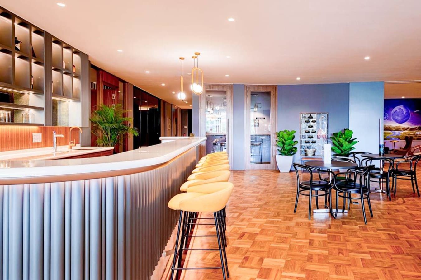 Modern coworking space with sleek bar seating, vibrant lighting, and stylish meeting areas on Stamford Road.