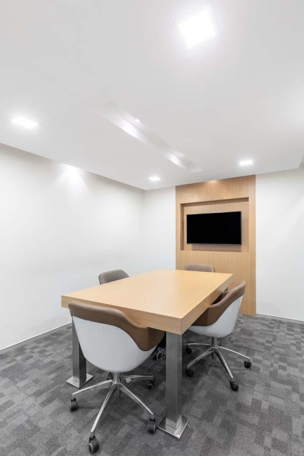 Sleek meeting room with modern table, ergonomic chairs, and built-in screen. Ideal for collaboration.