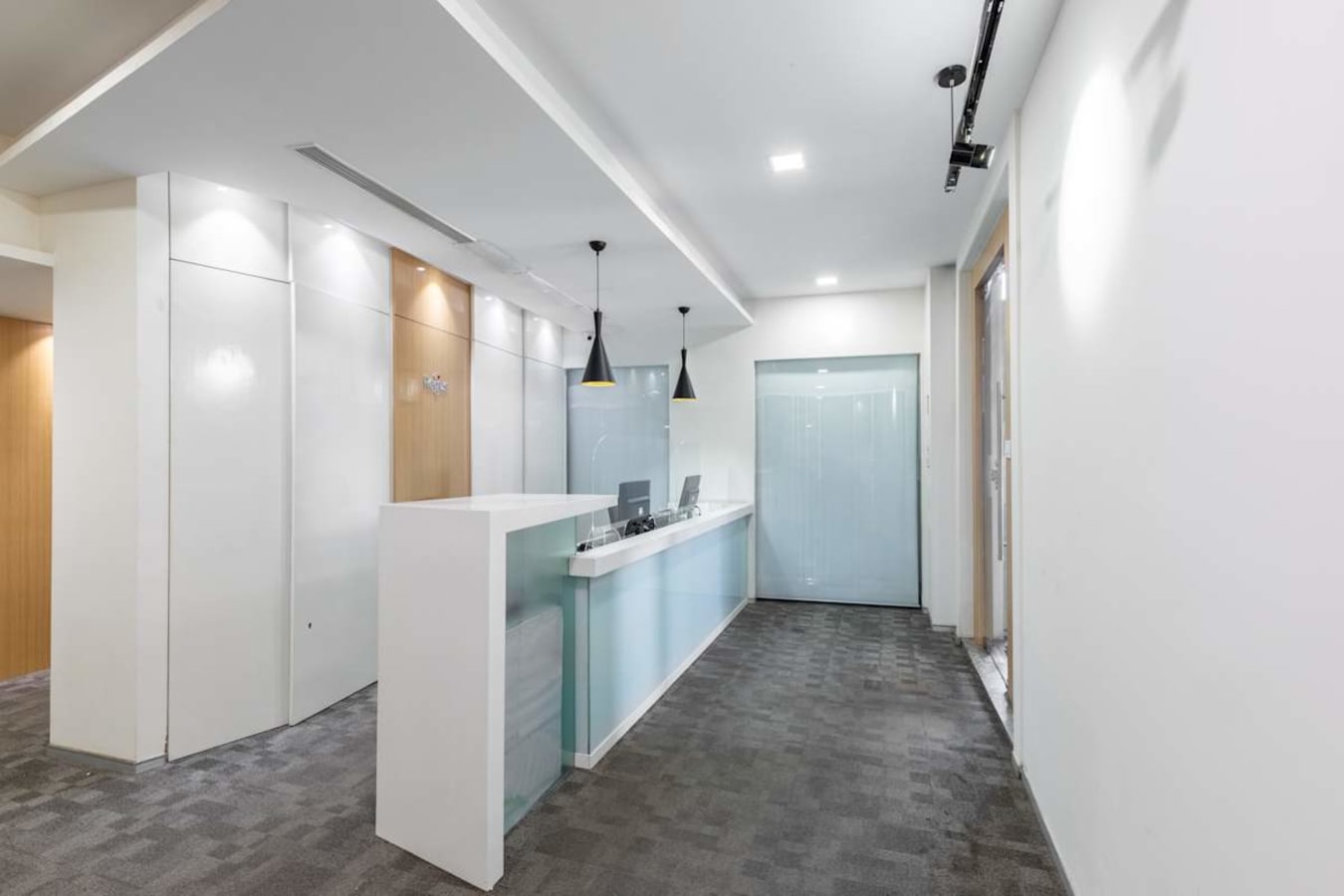 Modern coworking reception area with sleek design, ample lighting, and elegant finishes.