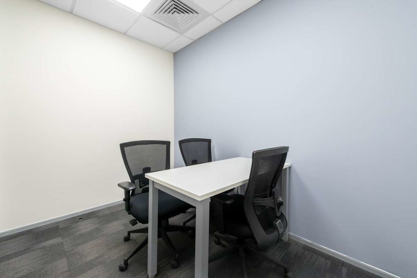 Modern coworking space with ergonomic chairs and a minimalist table on JNTU Road.