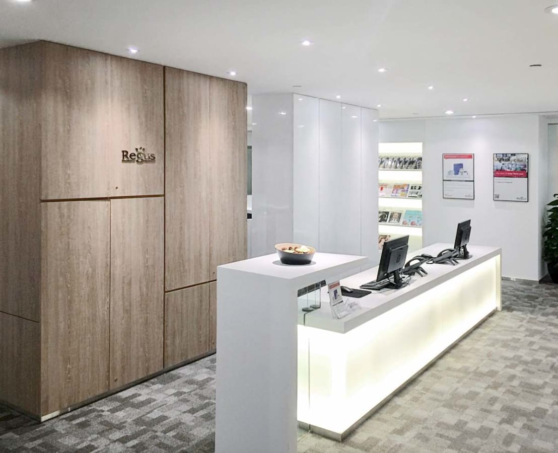 Modern reception area with sleek design and warm lighting in Queen's Road Central coworking space.