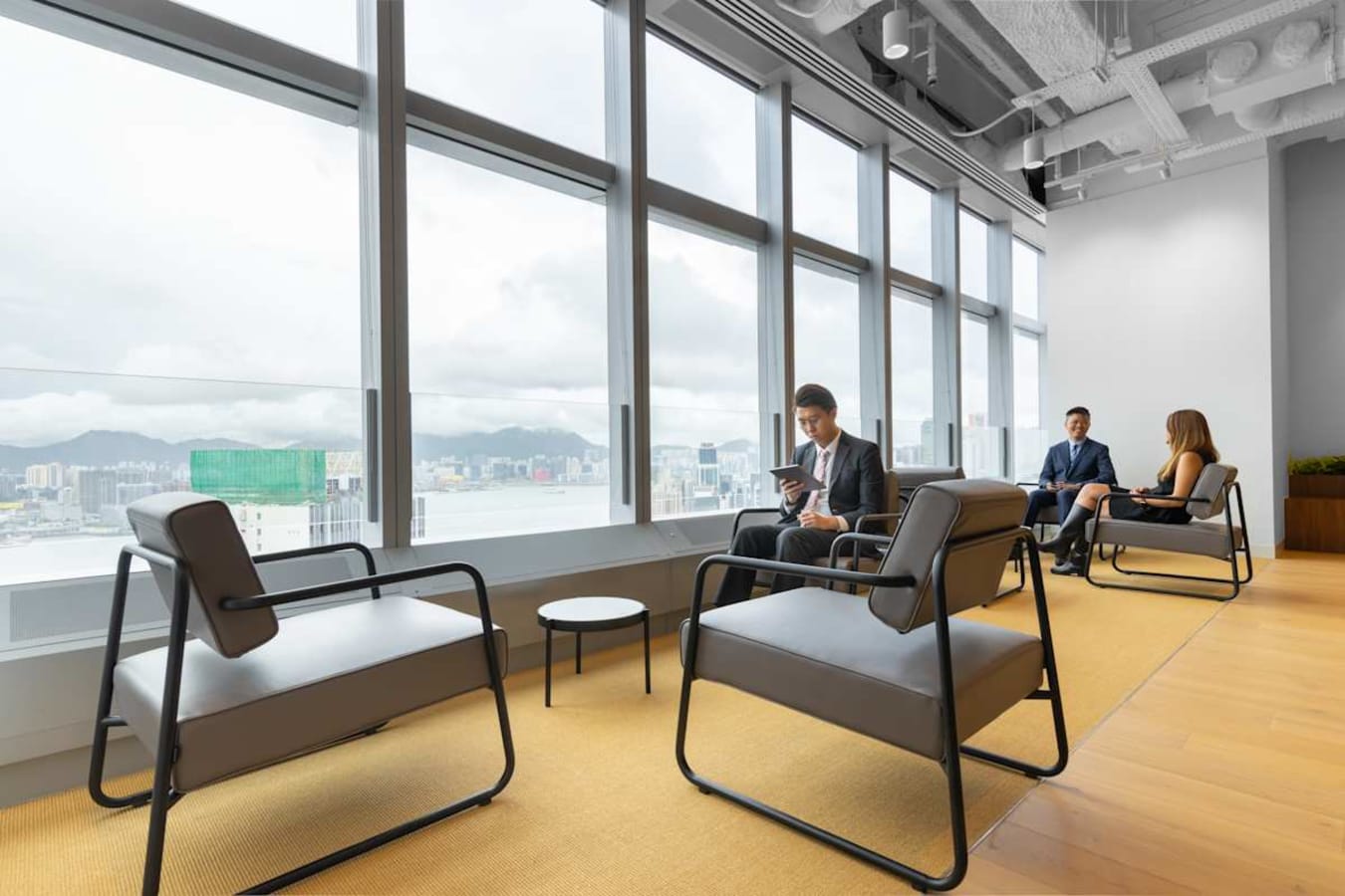 Modern coworking area with city views, featuring comfortable seating and abundant natural light.