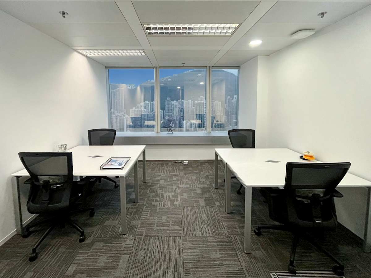 Modern coworking space with natural light, ergonomic chairs, and cityscape views.