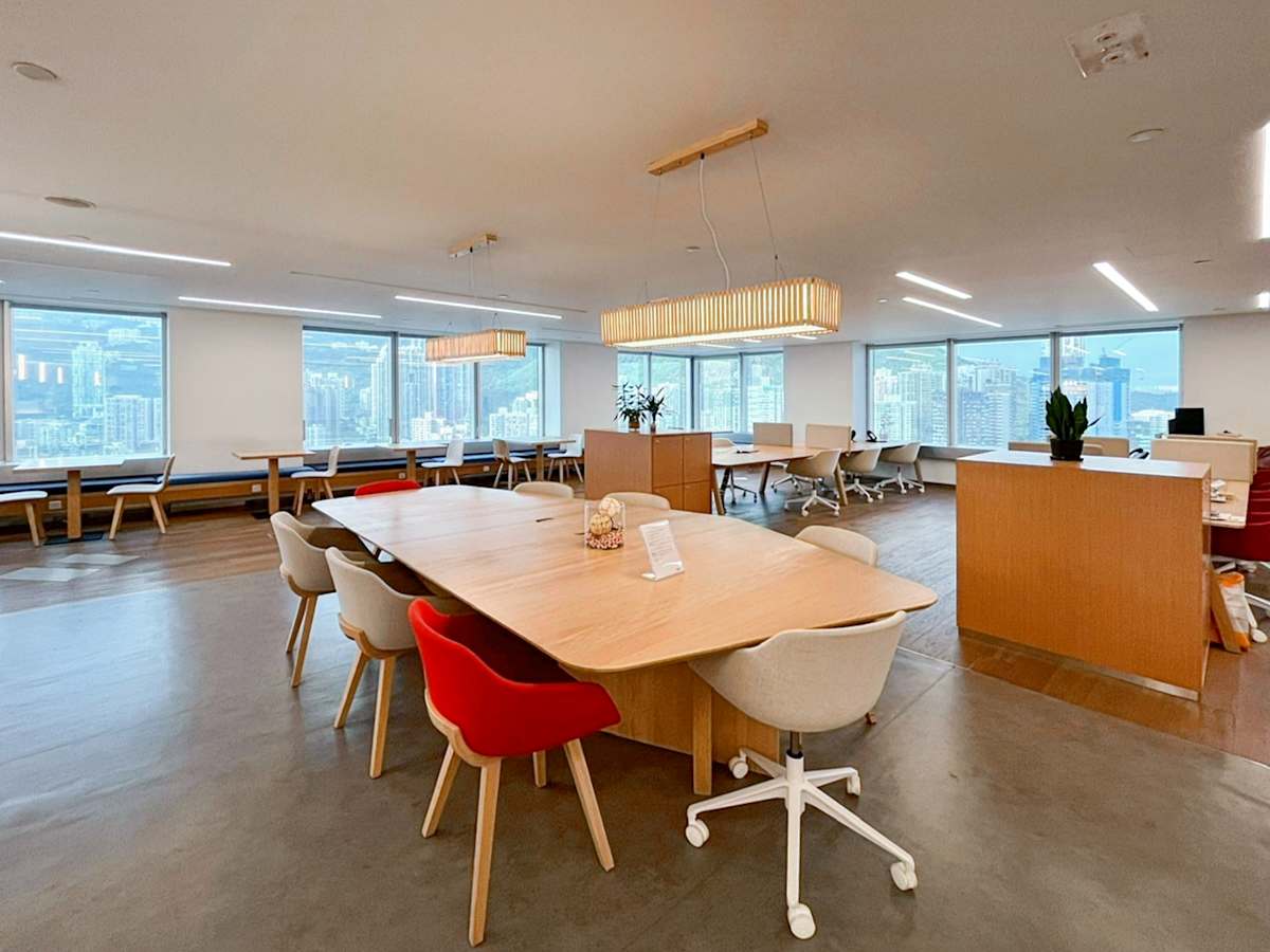 Modern coworking space featuring natural light, collaborative desks, and city views.