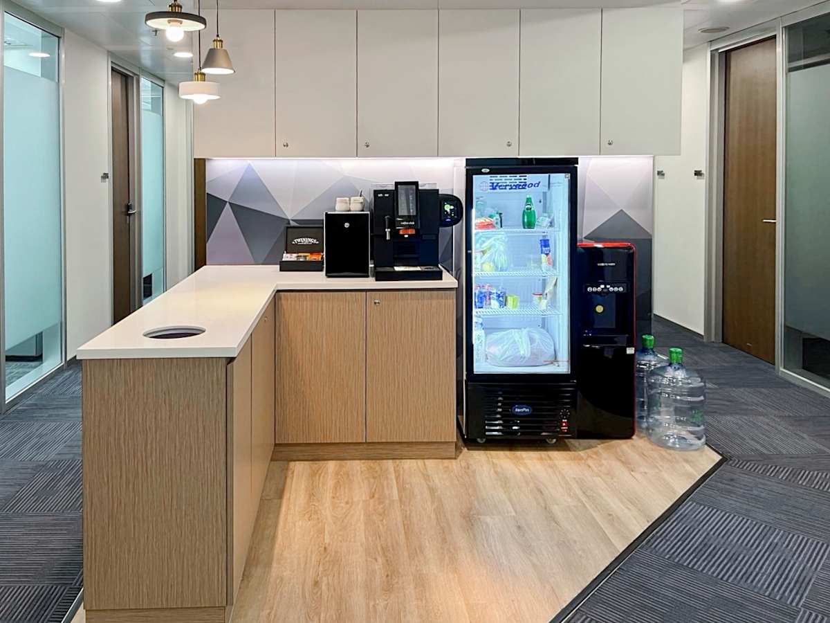 Modern kitchenette with refreshments and ample storage in Queen's Road Central coworking space.