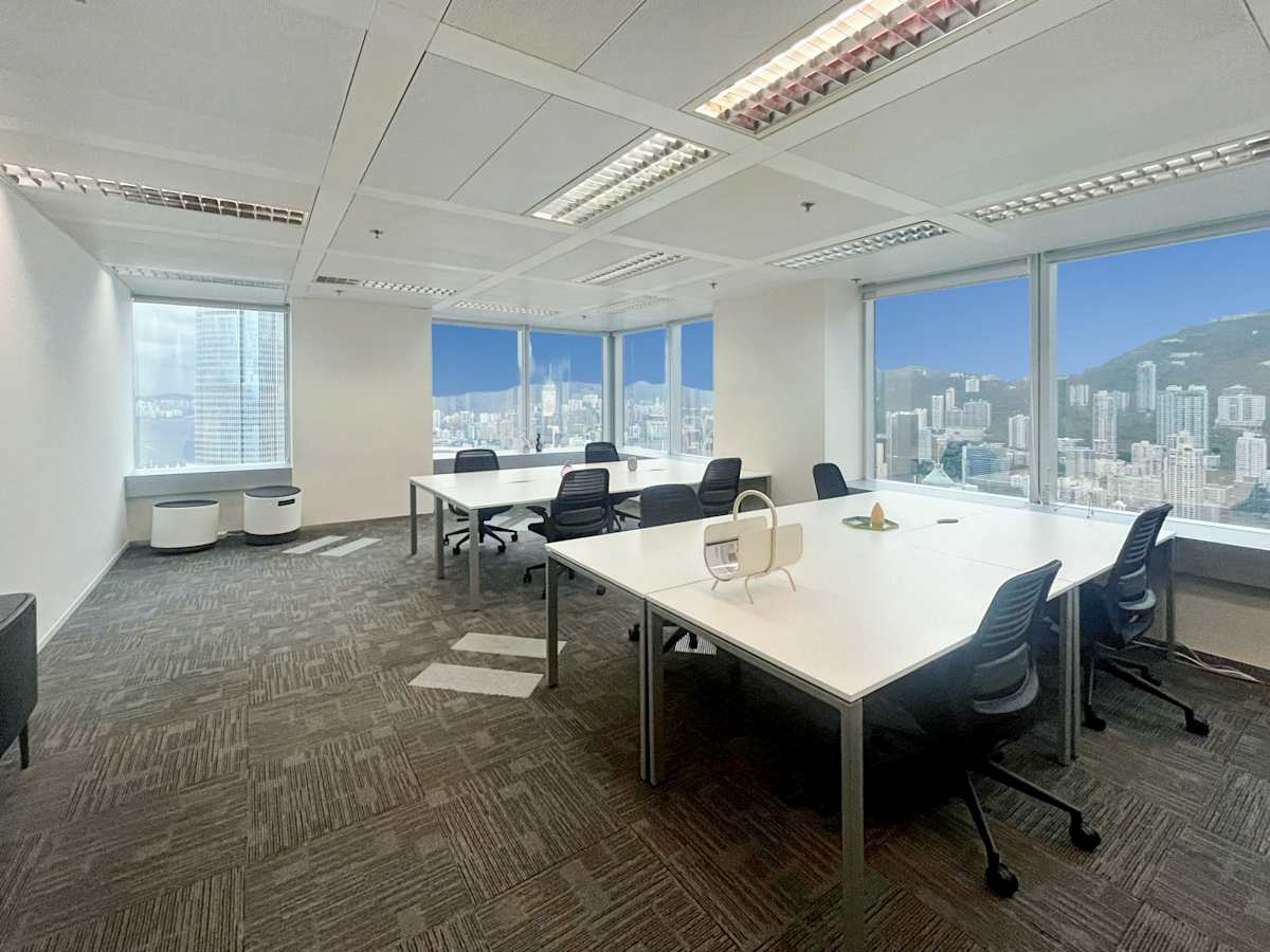 Bright, modern coworking space featuring large windows and cityscape views on Queen's Road Central.