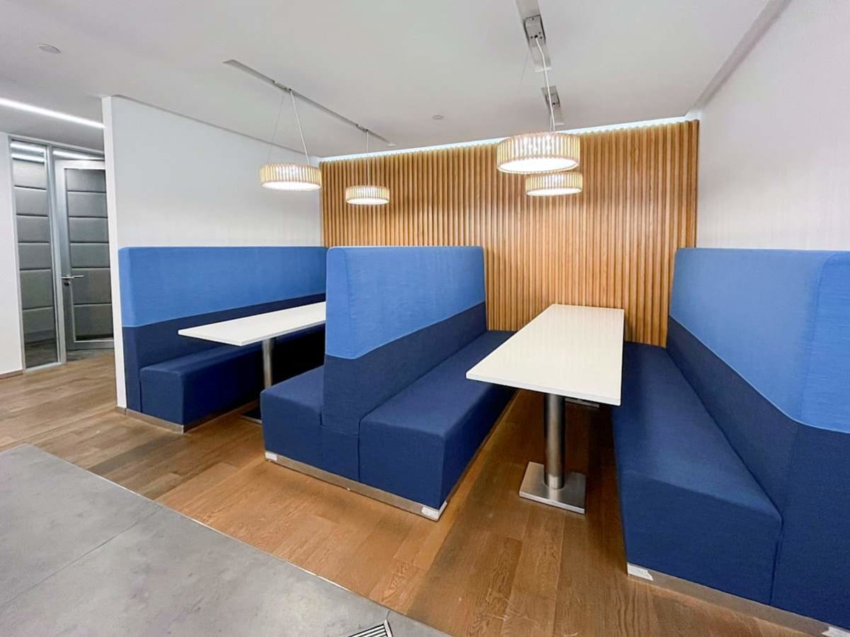 Modern coworking space with cozy booth seating and stylish lighting on Queen's Road Central.
