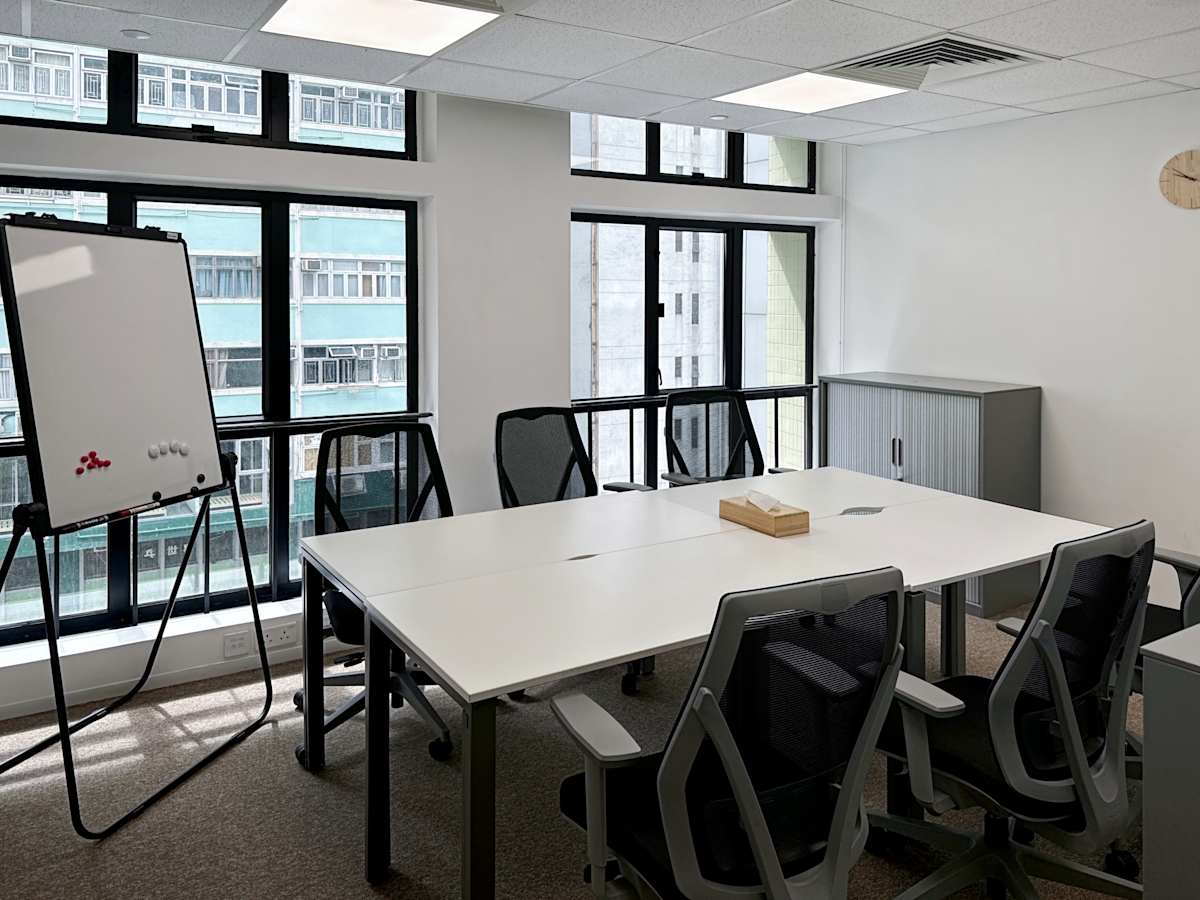 Modern coworking space with natural light, ergonomic chairs, and a whiteboard on Hennessy Road.