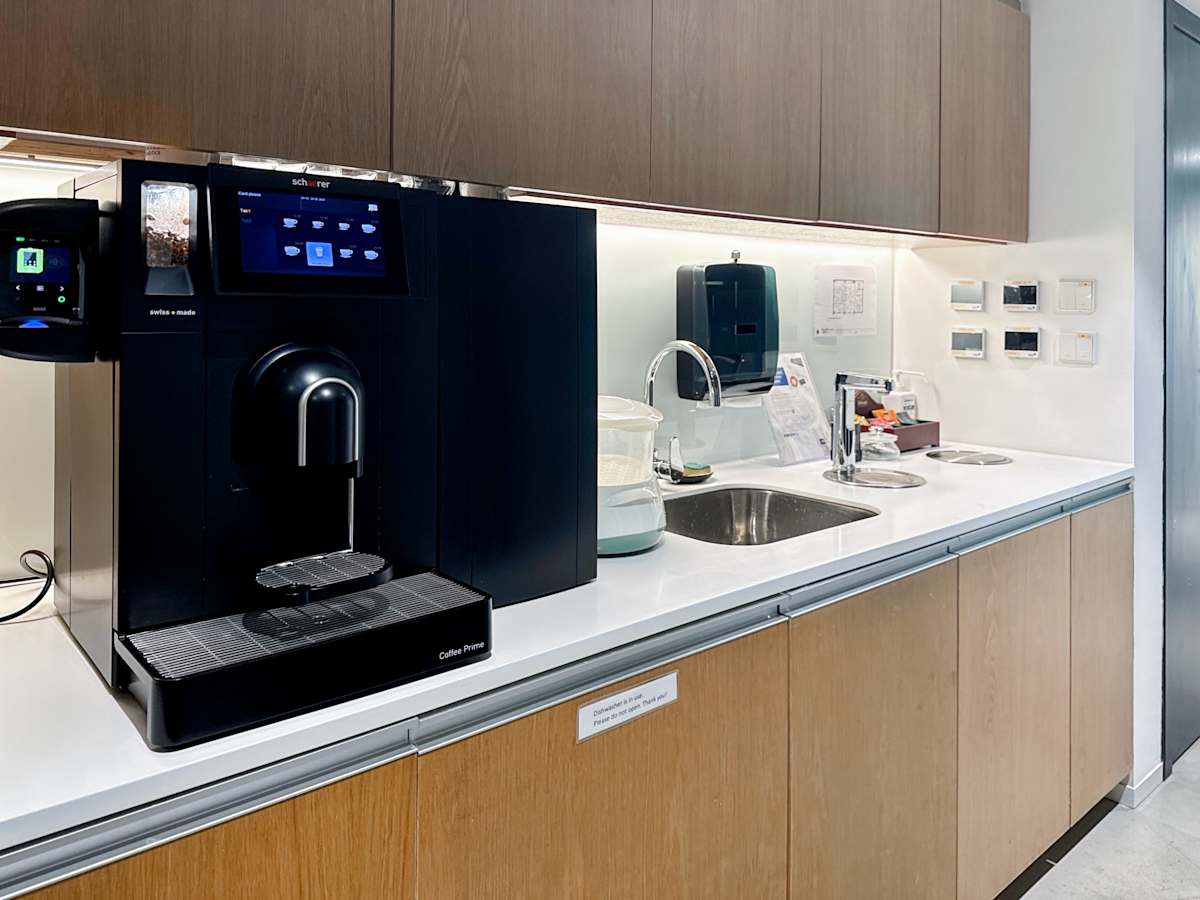 Modern kitchenette in a Hennessy Road coworking space with a sleek coffee machine and spacious counters.