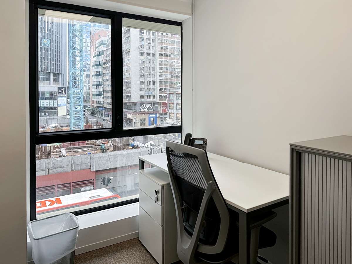 Modern coworking space with city views, ergonomic chair, and natural light on Hennessy Road.