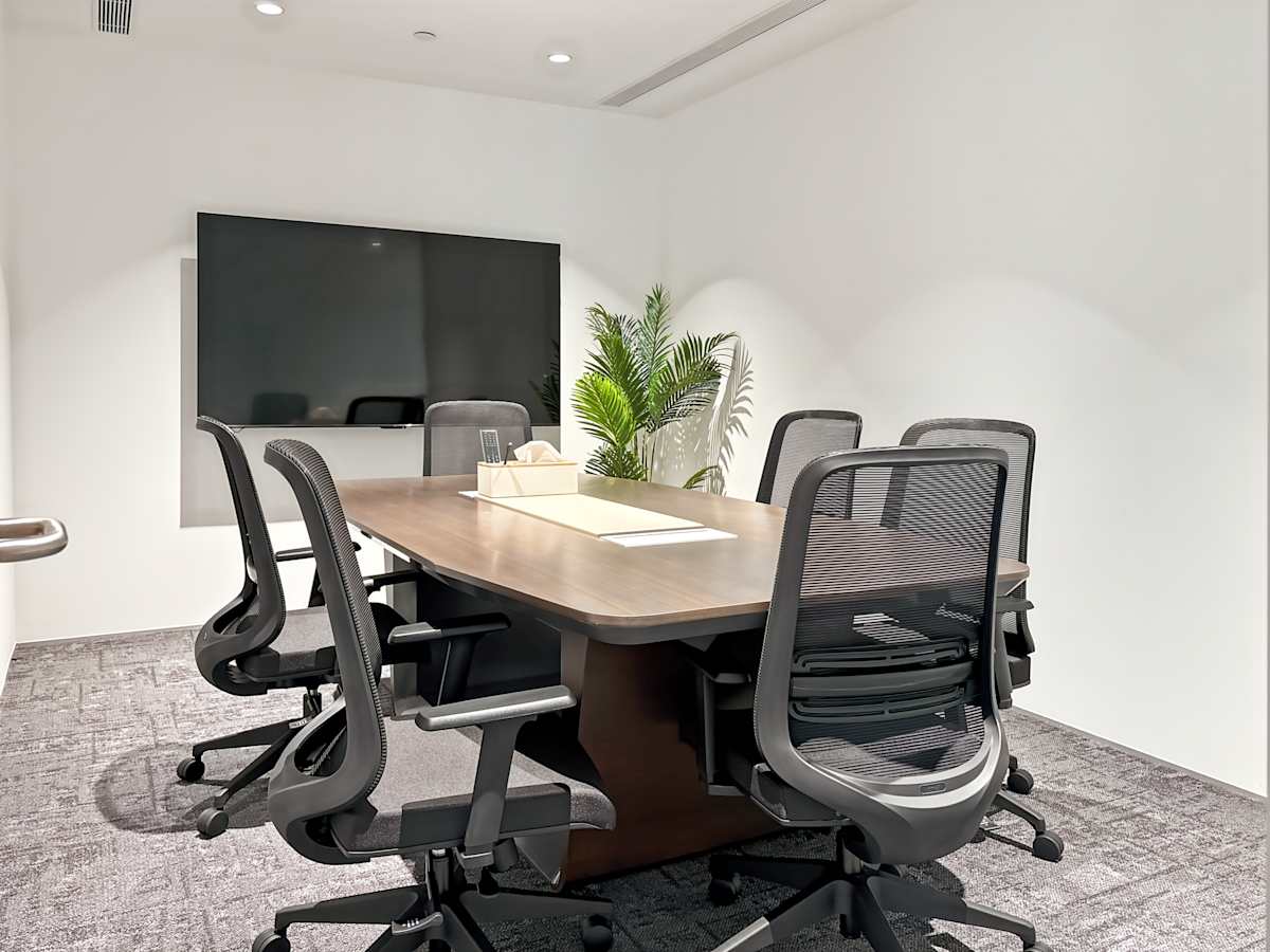 Modern meeting room with ergonomic chairs, large screen, and natural lighting. Ideal for collaboration.