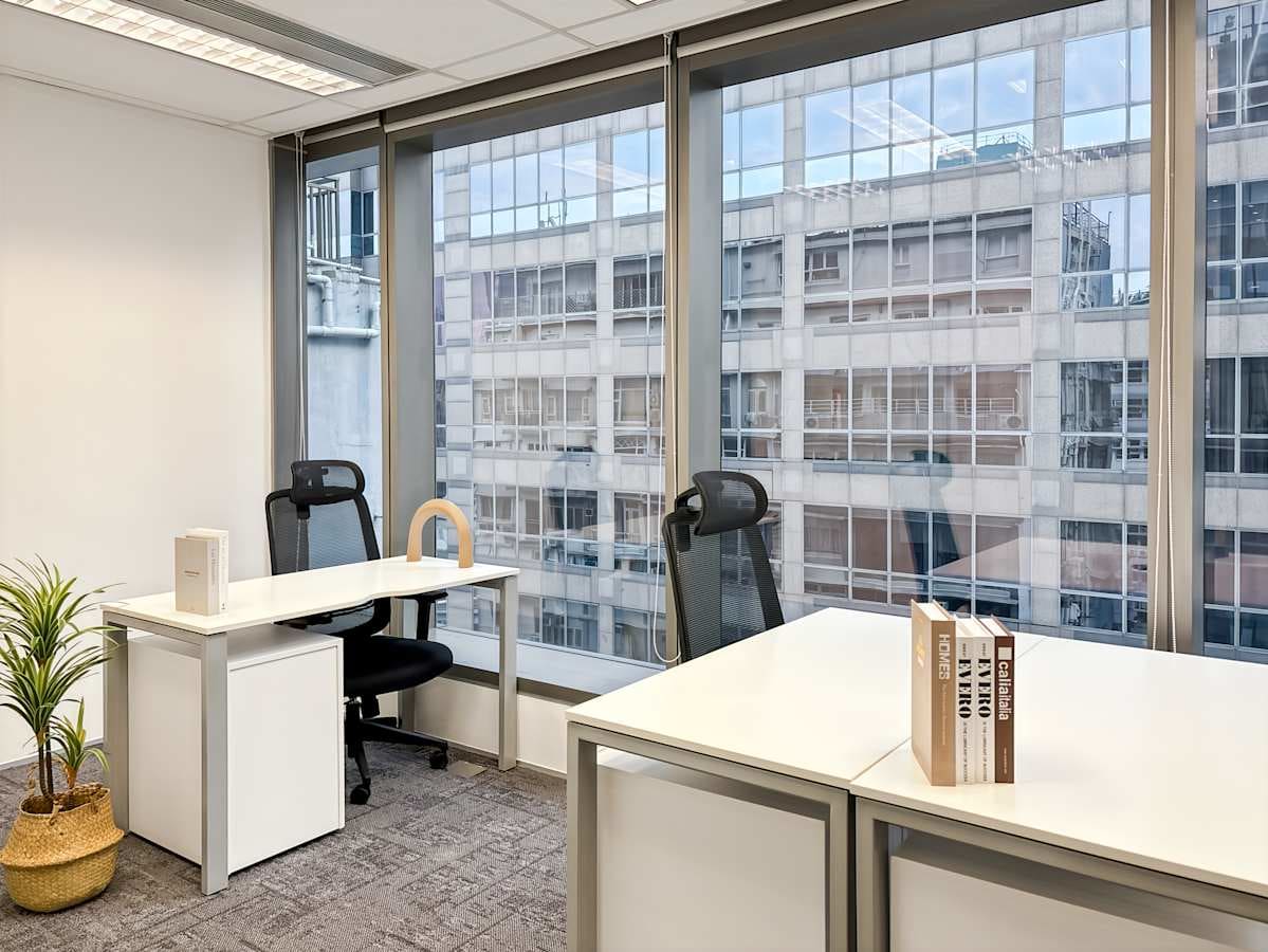 Bright coworking space with modern desks, ergonomic chairs, and city views. Perfect for productivity.
