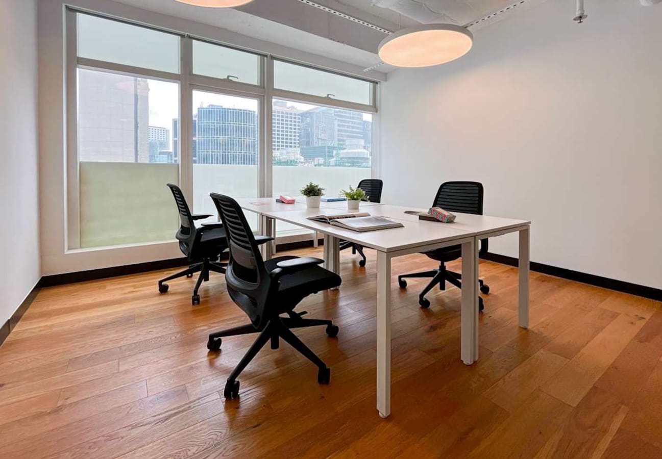 Bright coworking space with modern desks, ergonomic chairs, and city views on Wyndham Street.