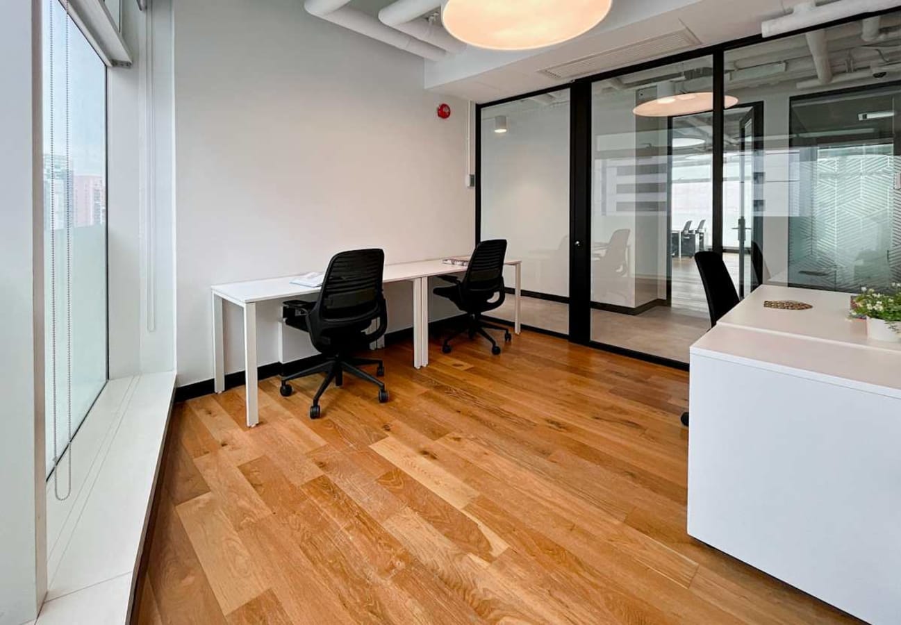 Bright, modern coworking space with hardwood floors, sleek desks, and natural light on Wyndham Street.