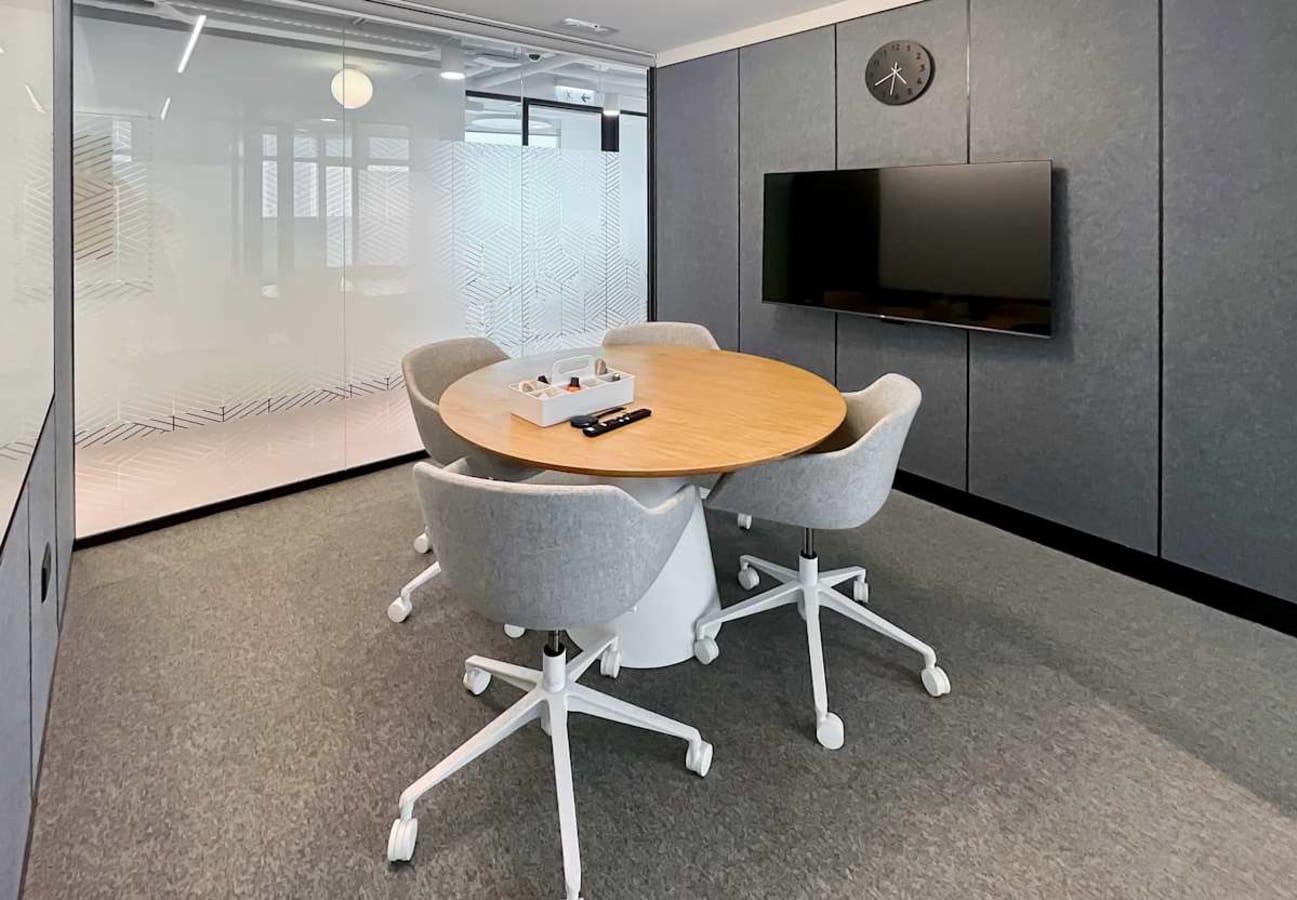 Modern meeting room on Wyndham St. with sleek decor and video conferencing setup.