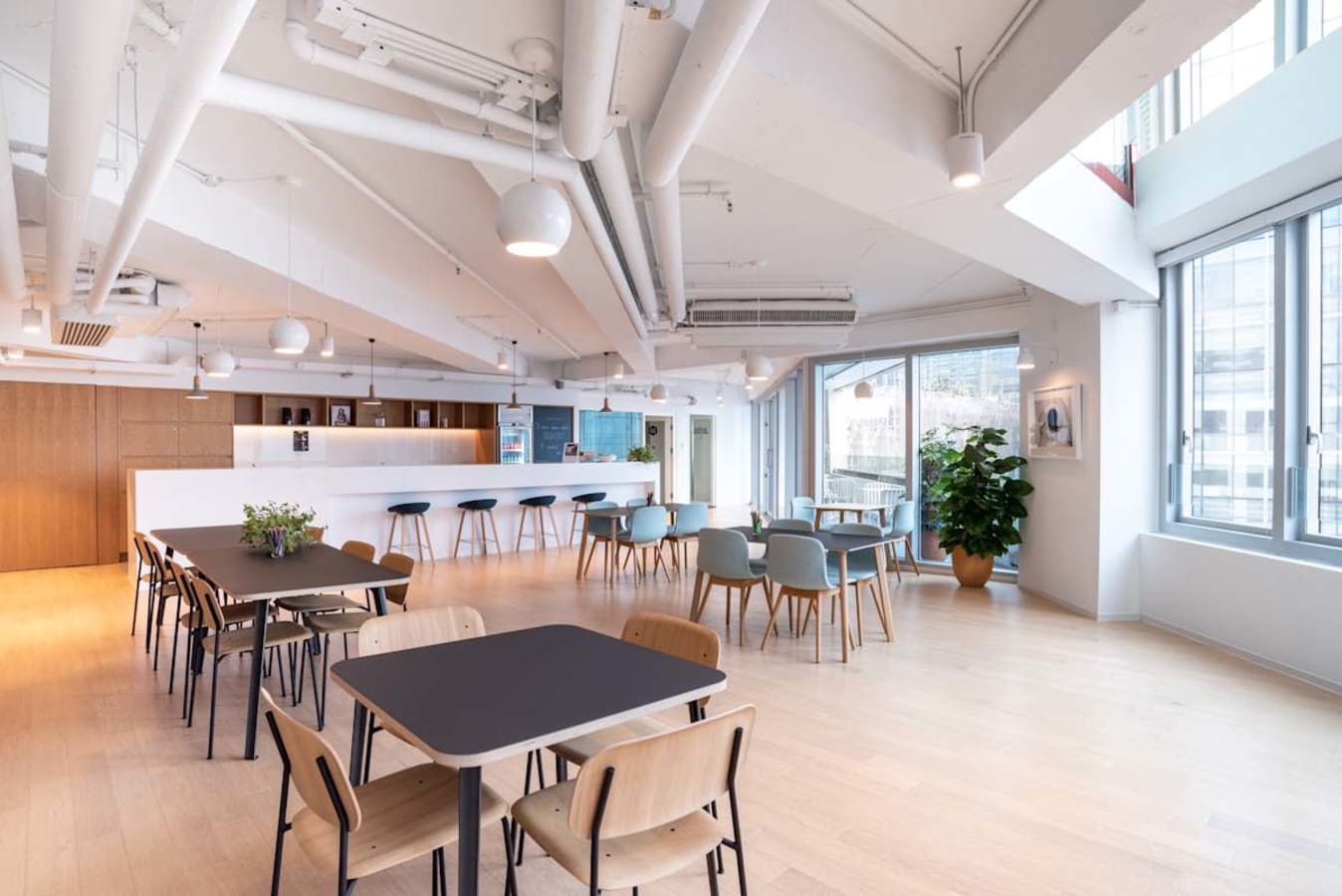 Bright coworking space on Wai Yip Street with modern seating, natural light, and a sleek bar area.