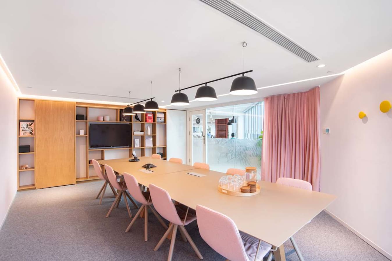 Modern collaborative space with natural light, stylish seating, and equipped for meetings.