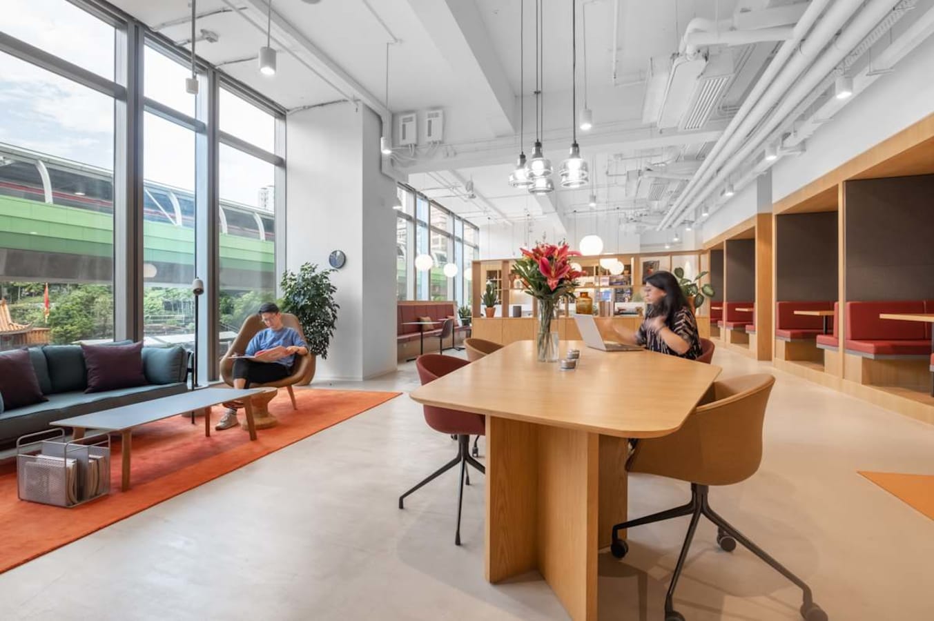 Modern coworking space with natural light, open seating, and collaborative areas.
