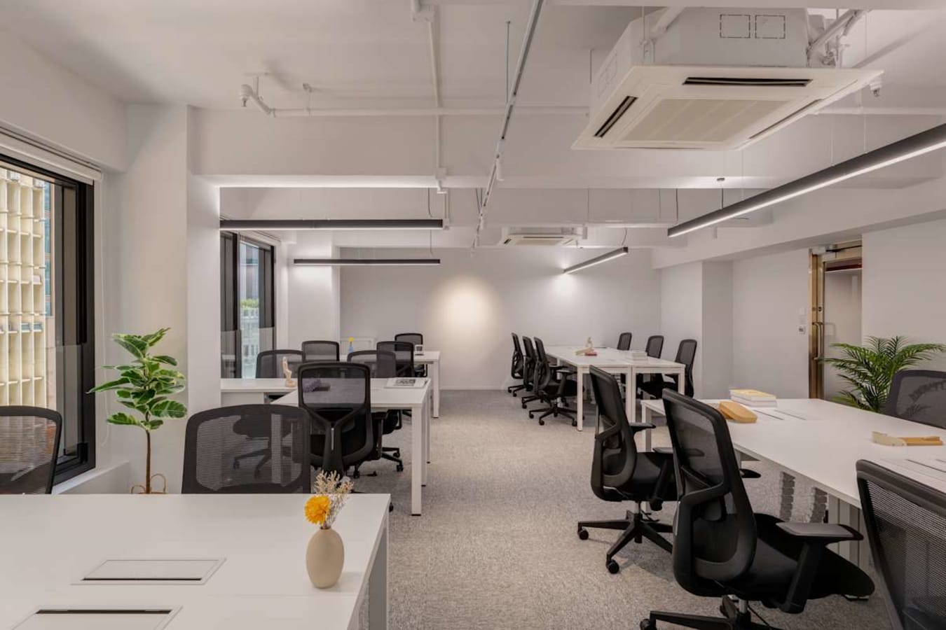 Modern coworking space with open layout, natural light, and ergonomic seating in 德輔道中.