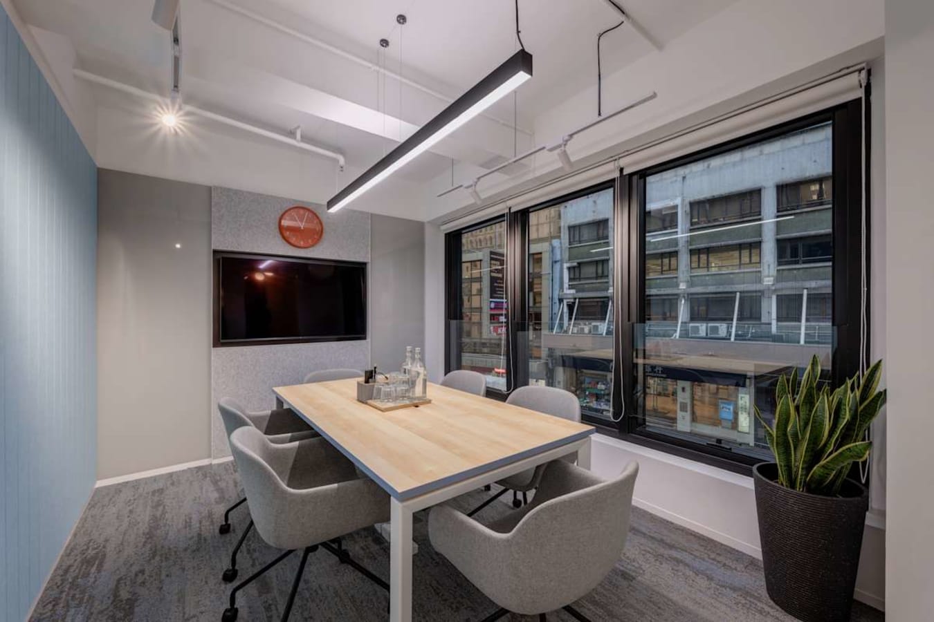 Bright meeting room with modern furniture and large windows overlooking bustling 德輔道中.