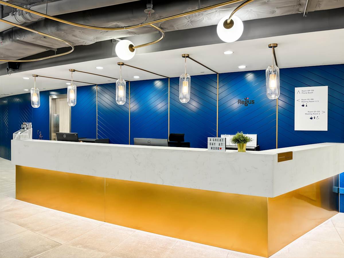 Modern coworking reception with sleek blue accents and elegant lighting on Prince Edward Road West.
