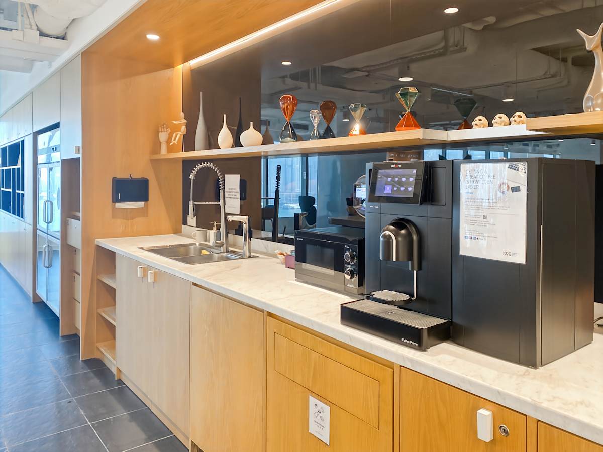 Sleek coworking space with a modern kitchenette. Ideal for collaboration and creativity.