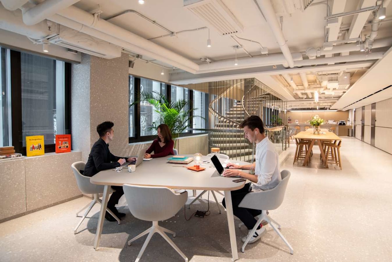 Modern coworking space with open layout, natural light, and collaborative seating on Connaught Road Central.