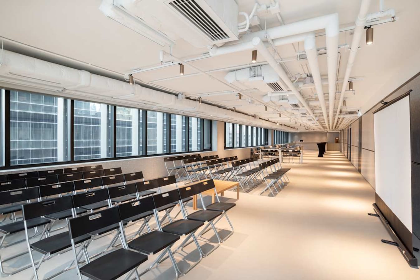 Spacious coworking area on Connaught Road Central with modern seating and abundant natural light.