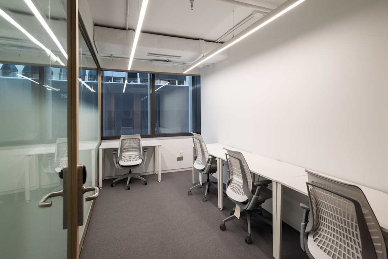 Modern coworking space with natural light, ergonomic chairs, and sleek desks in Connaught Road Central.