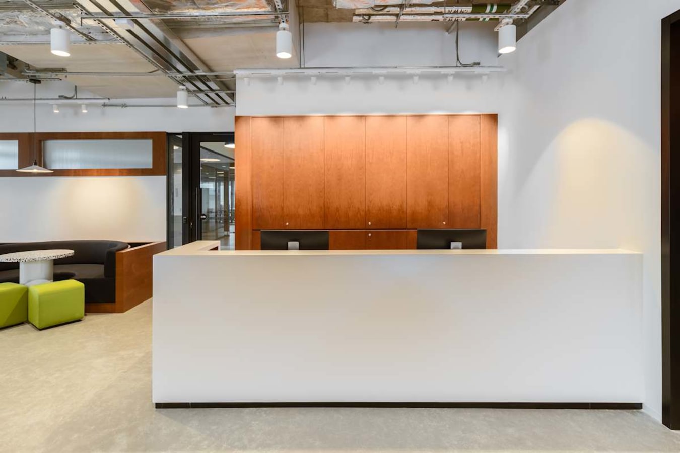 Modern coworking space with sleek reception, cozy breakout area, and inviting lighting.