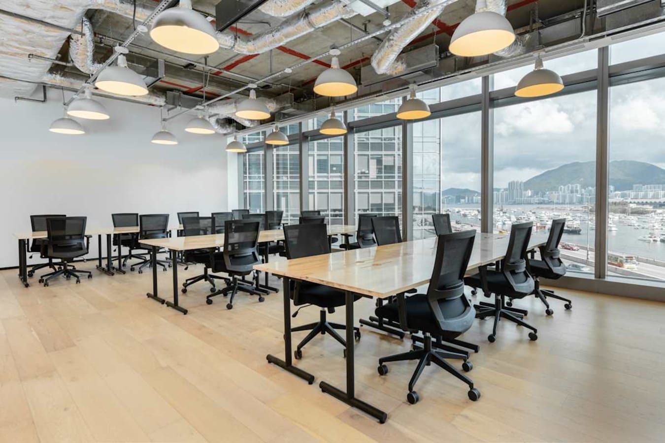 Modern coworking space with open layout, natural light, and stunning city views on Hoi Bun Road.