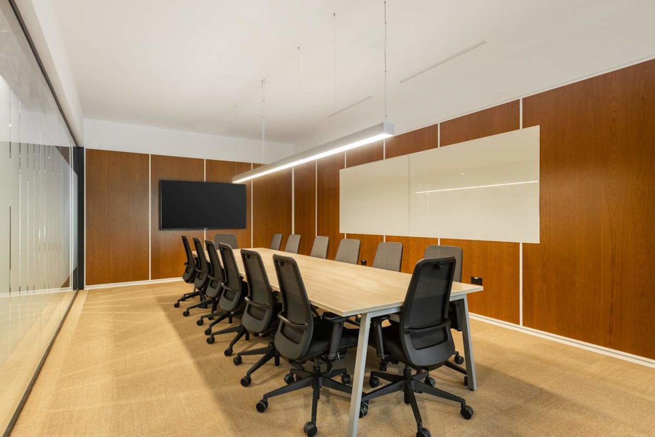 Modern meeting room with sleek chairs, a large table, and a digital screen on Hoi Bun Road.
