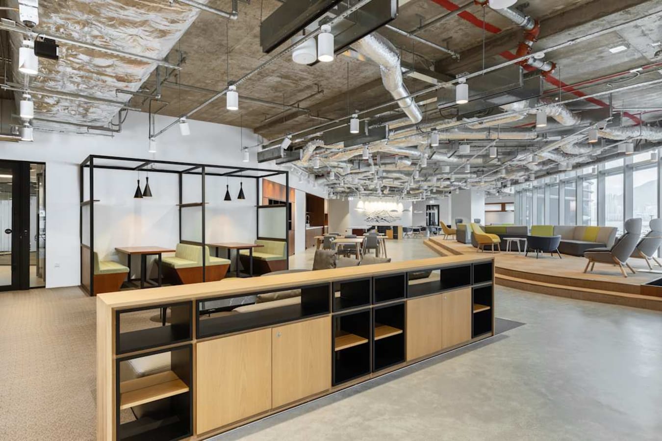 Modern coworking space with open layout, cozy booths, and ample natural light.