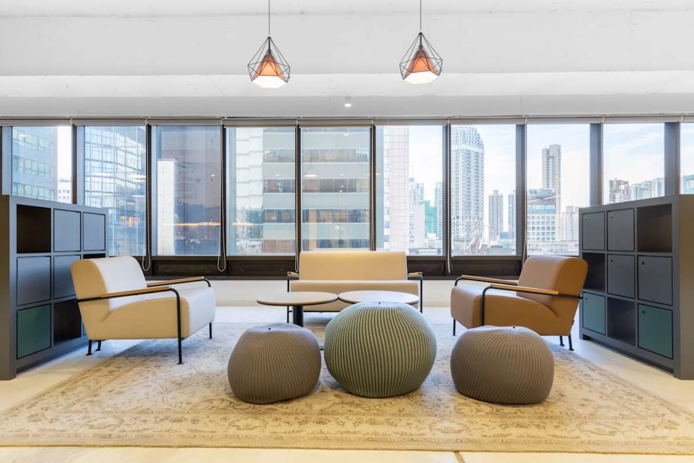 Bright coworking lounge with modern seating and city views, perfect for collaboration.