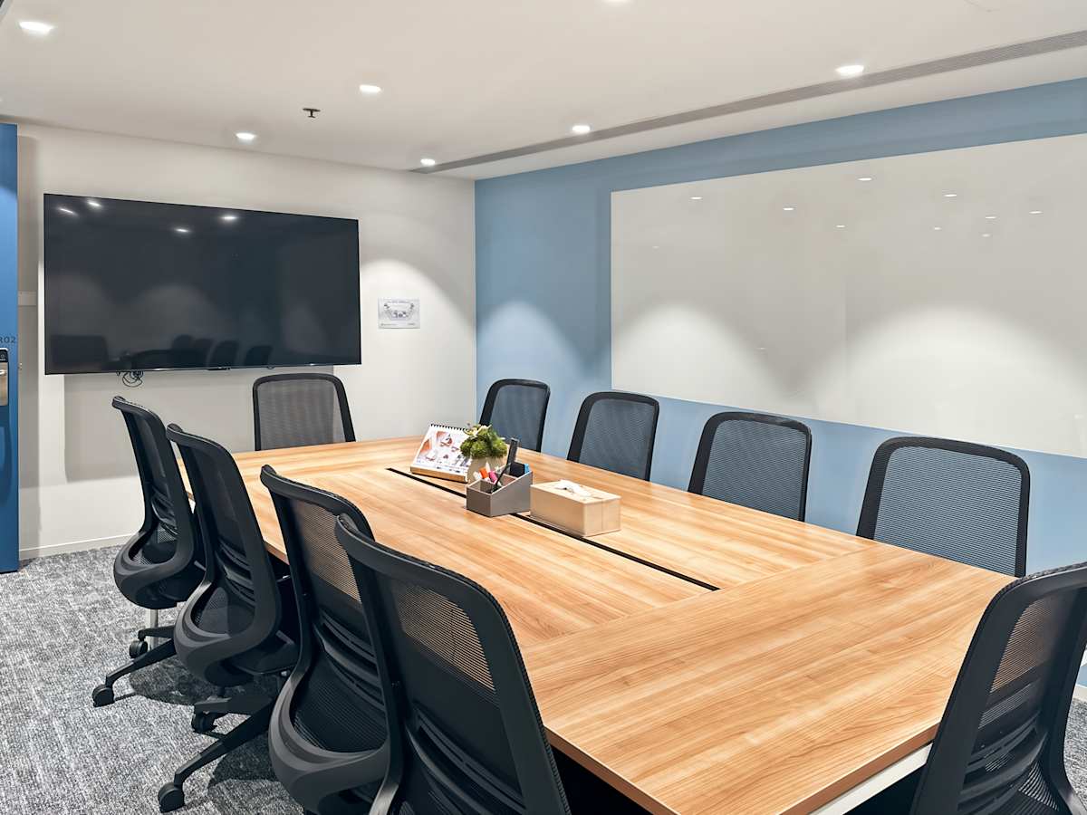 Modern conference room with smart TV, whiteboard, and sleek furnishings in Nathan Road coworking space.