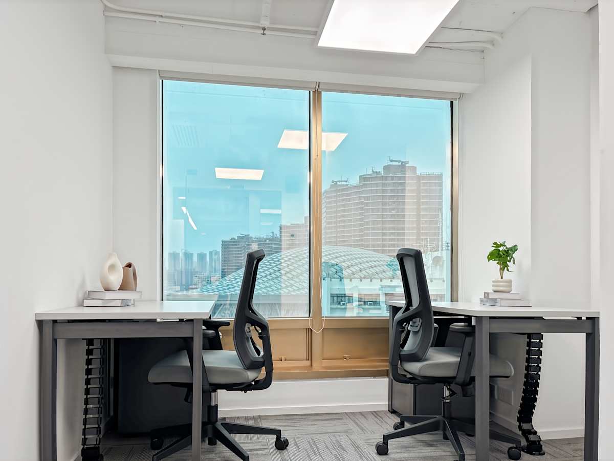 Bright coworking space with ergonomic chairs, sleek desks, and a stunning city view.