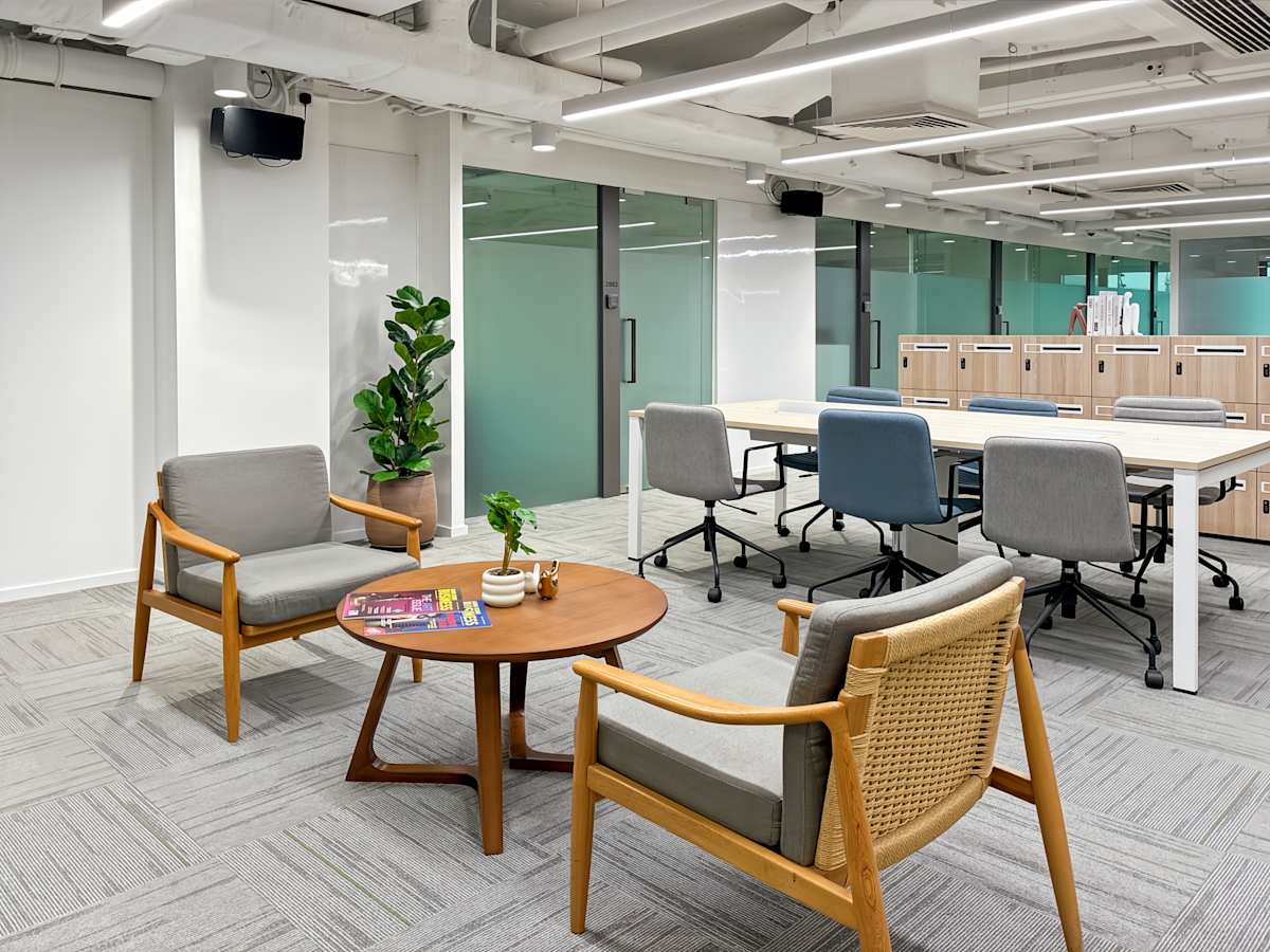 Modern coworking space with stylish seating, meeting tables, and natural light. Ideal for collaboration.