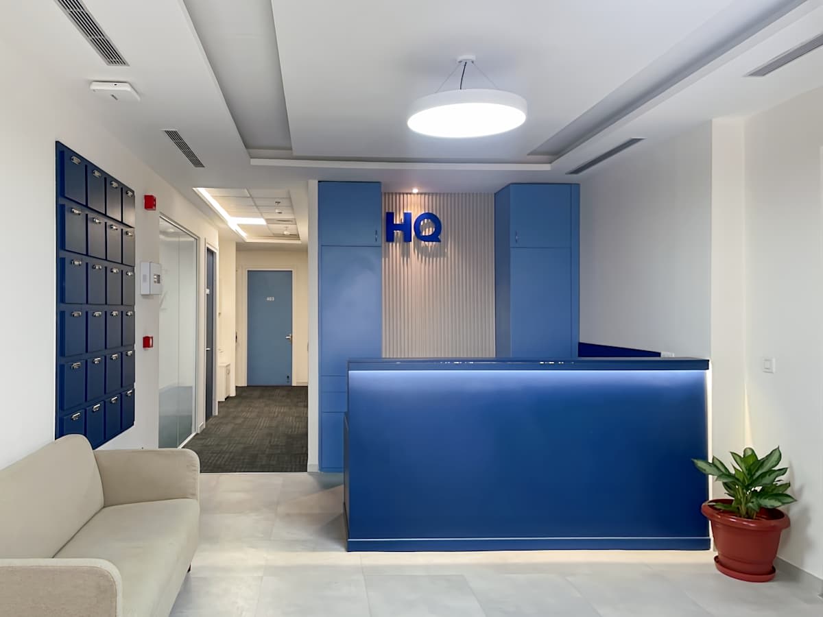 Modern reception area with chic blue accents, cozy seating, and ample natural light on Haridwar Bypass Road.
