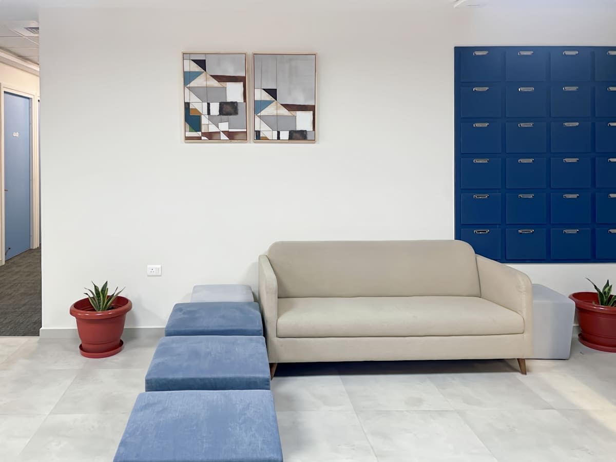 Modern coworking space with cozy seating, vibrant lockers, and stylish decor for a productive environment.