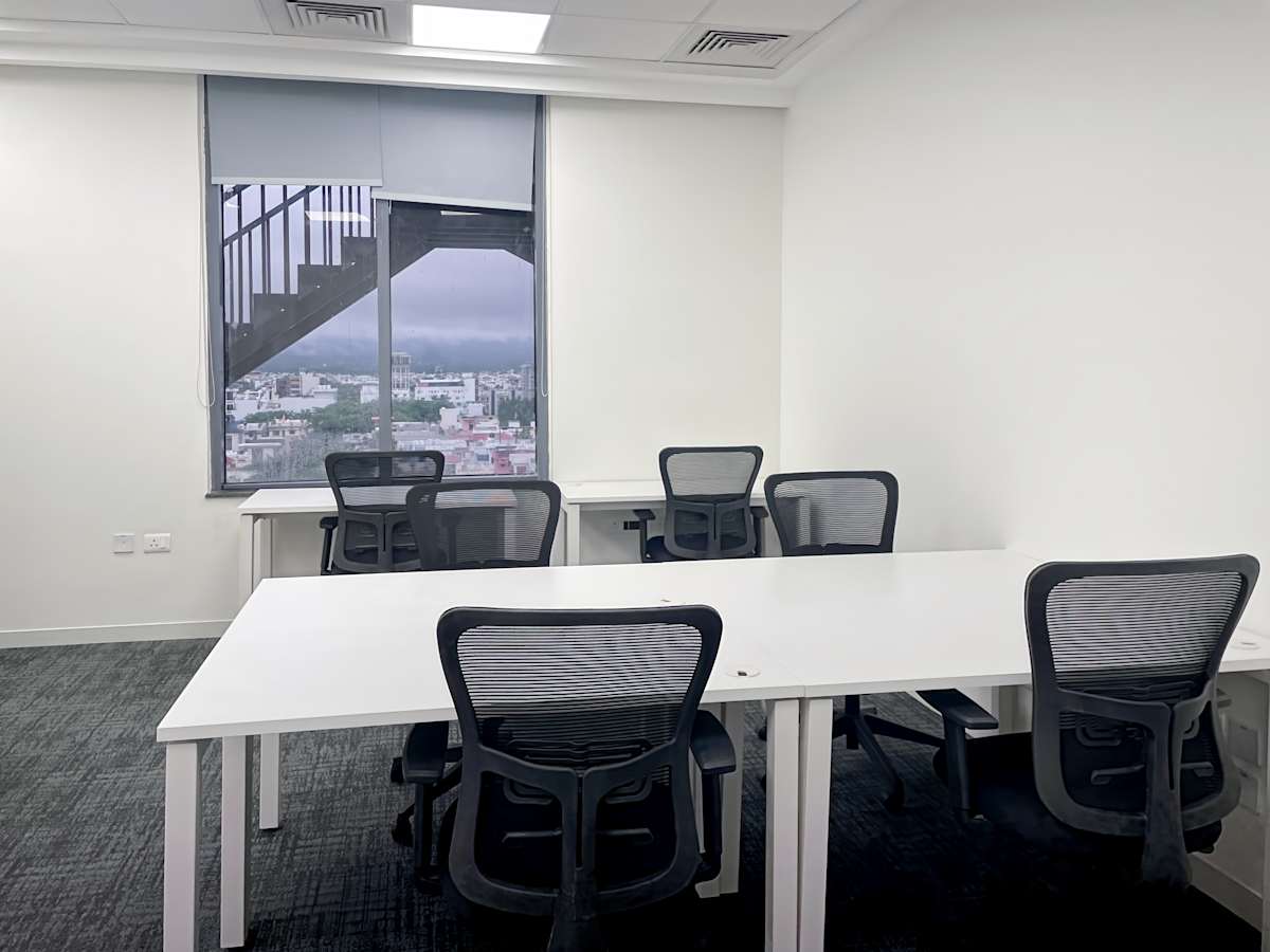 Modern coworking space with ergonomic chairs, ample natural light, and a serene view.
