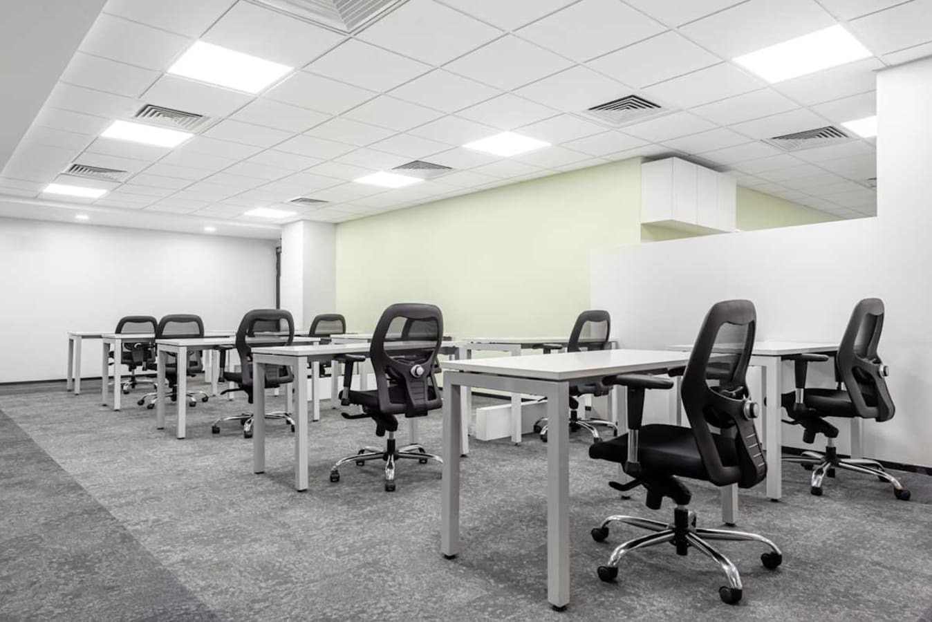 Spacious coworking area with modern desks and ergonomic chairs, ideal for productivity.