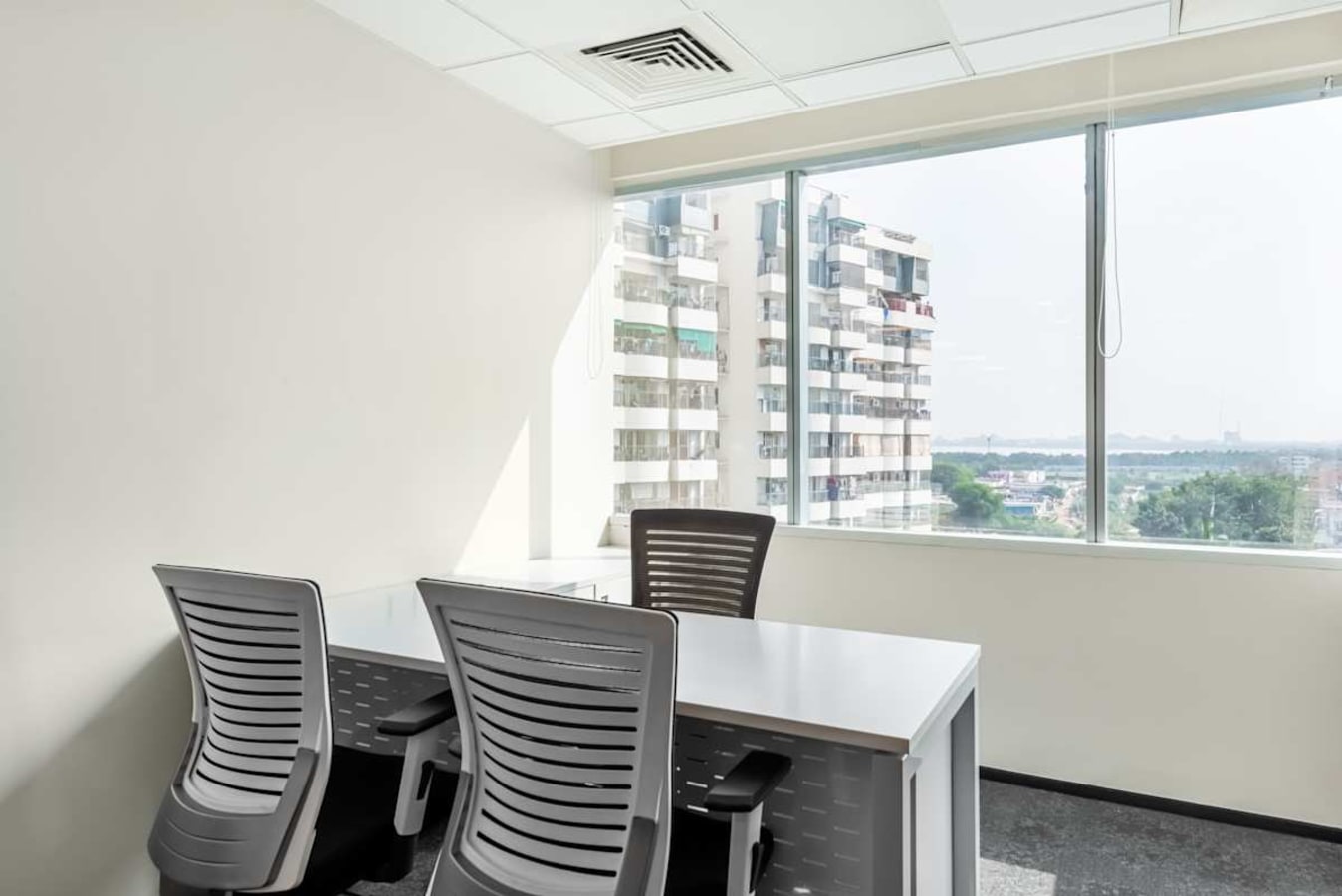 Bright, modern workspace with natural light and city view, ideal for focused productivity.